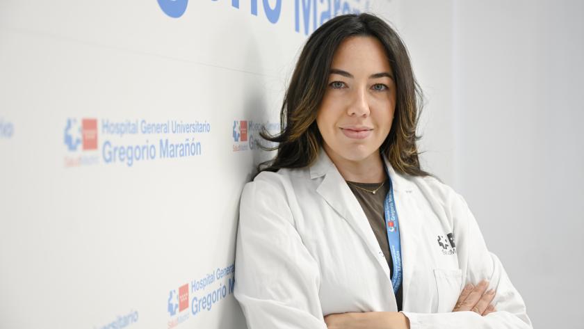Sara Álvarez, residente de quinto año de Cirugía Oral y Maxilofacial del Gregorio Marañón Médico posando para una foto con un photocall detrás