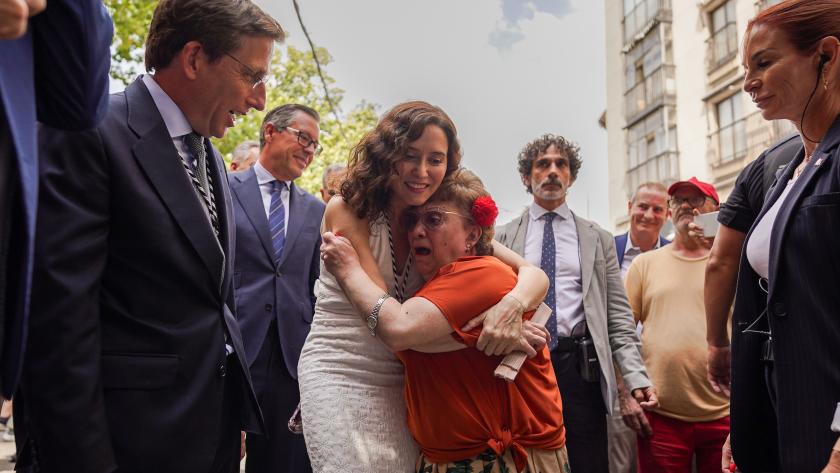 Ayuso abraza a una persona mayor