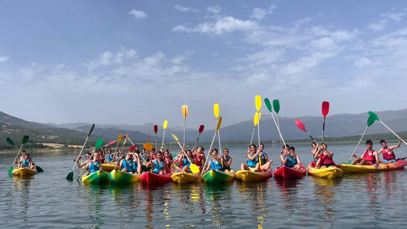 Grupo de jóvenes en piraguas levantando las palas