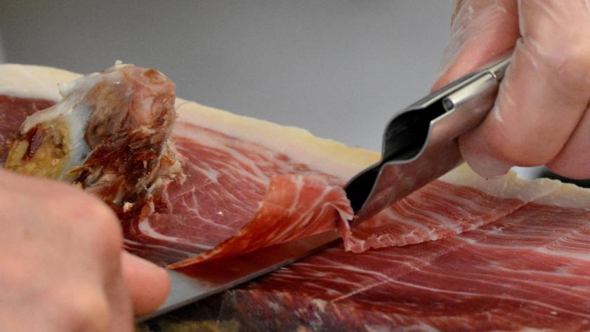 Unas manos cortando jamón serrano