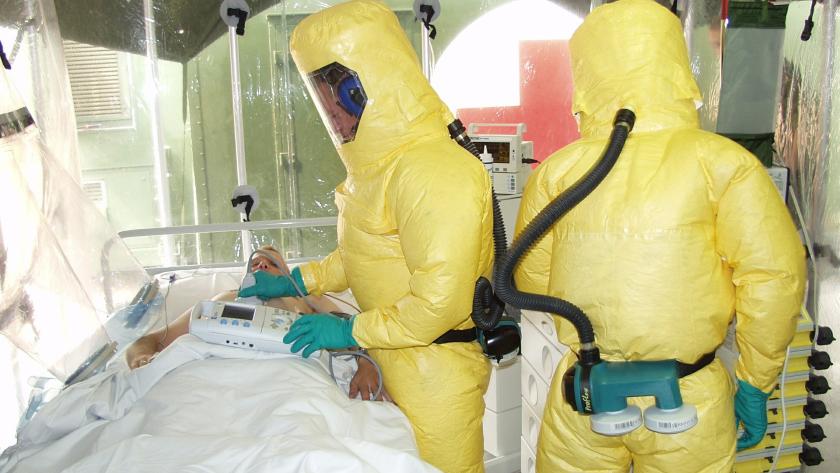 Profesionales con traje de protección Es un aislamiento de un paciente, donde se observa a los médicos llevar trajes de Protección Personal de color amarillo
