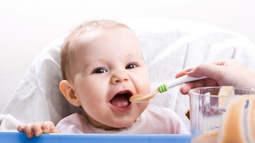 Madre dando de comer a bebé