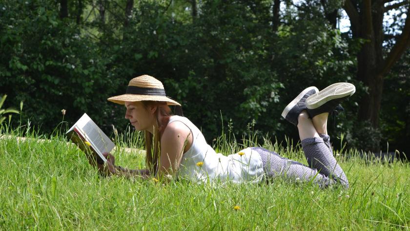 chica tumbada en la hierba leyendo