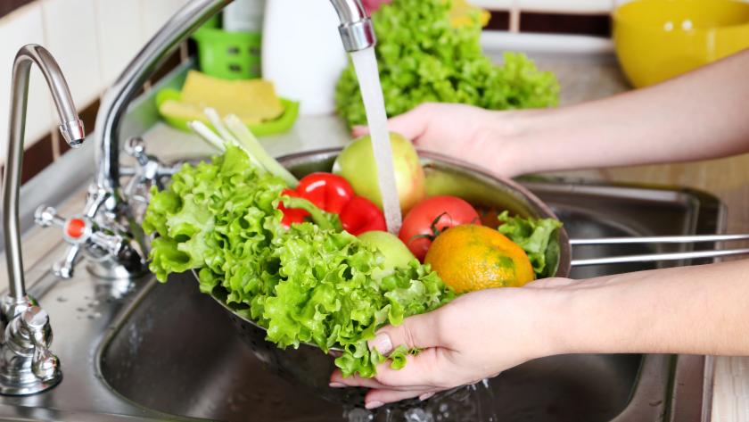 Lavando varios vegetales bajo el grifo