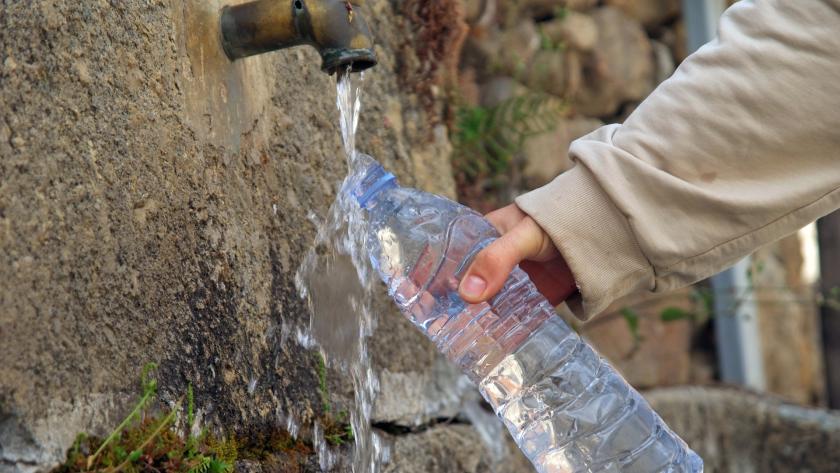 Persona rellenando una botella en una fuente
