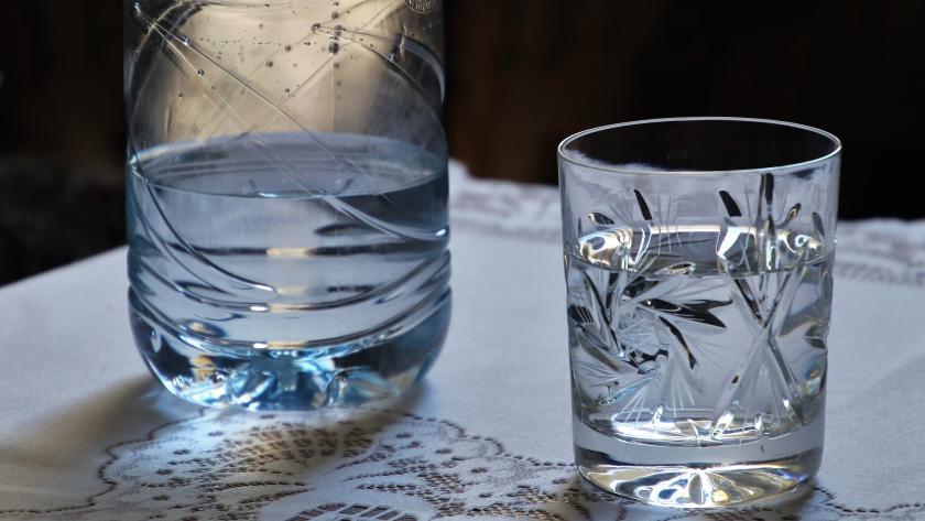 vaso de agua con botella al lado