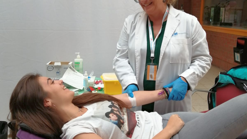 Extracción de muestra de sangre para posterior registro como donante de médula Una joven en la camilla mientras uan enfermera le extrae muestra de sangre para registro como donante de médula