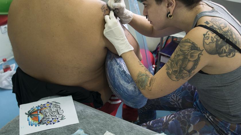 Chica haciendo un tatuaje