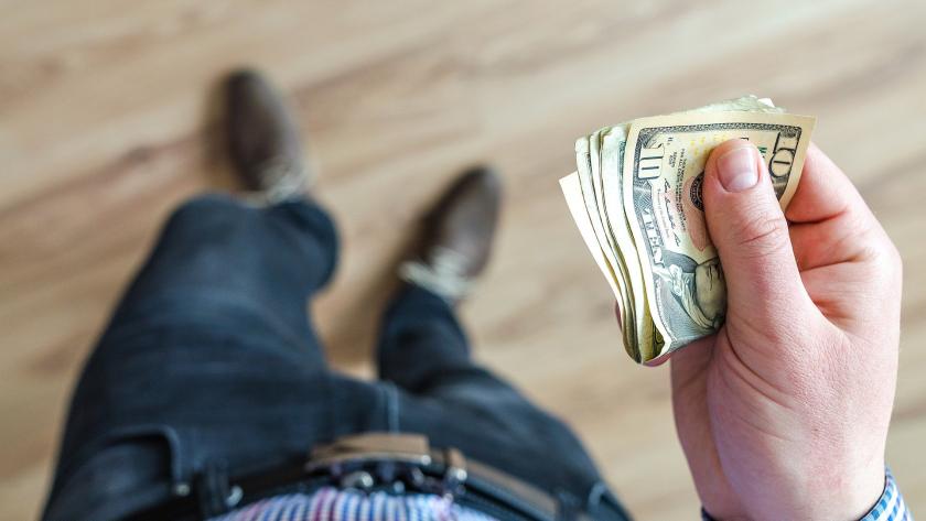 hombre con dinero en la mano visto desde arriba