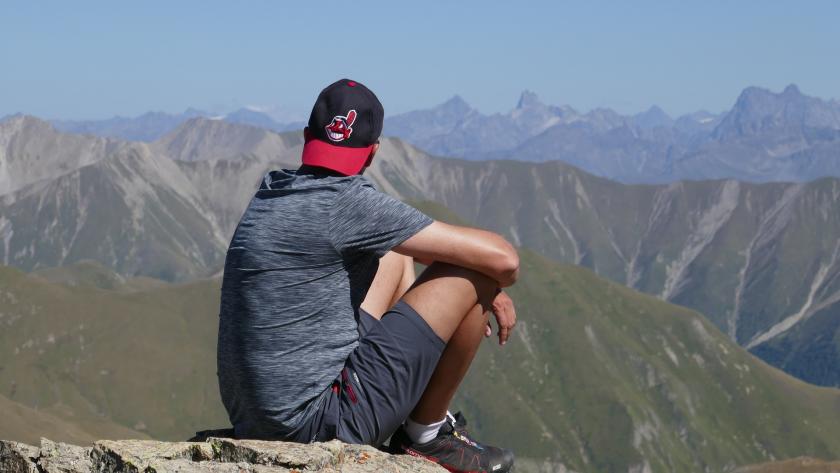 chico sentado en lo alto de la montaña 