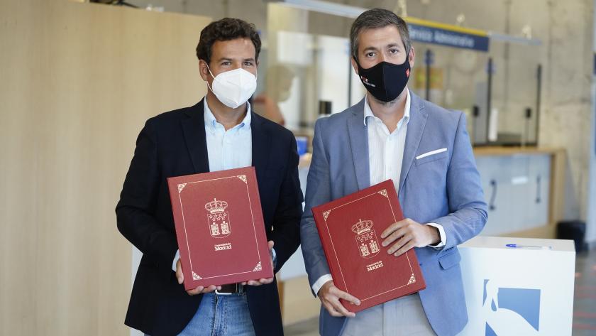 El viceconsejero junto al alcalde de Las Rozas de Madrid con una carpeta burdeos en las manos en la que se ve el escudo de Madrid