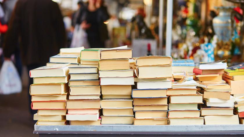 Libros apilados encima de una mesa en la calle