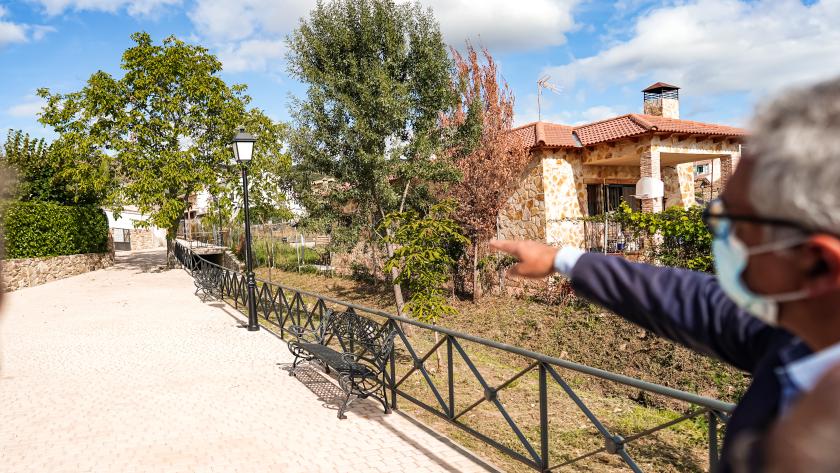 el consejero caminando por un paseo ajardinado del municipio