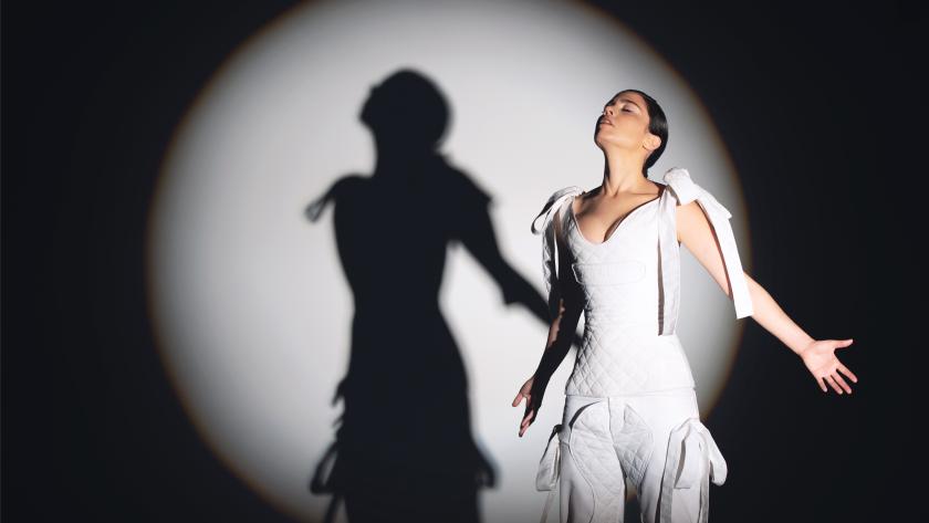 Javiera Mena Bailarina en pose con brazos abiertos vestida de blanco