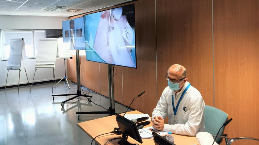 Curso de Oftalmología con cirugías en directo en el Hospital de Fuenlabrada Un hombre sentado junto una pantalla que muestra una cirugía
