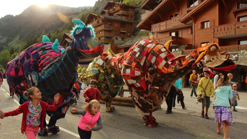Clásicos en Verano y el teatro de calle destacan en las propuestas culturales de la Comunidad de Madrid para el fin de semana Unos niños corren entre personas disfrazadas de dinosaurios