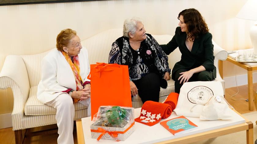 Díaz Ayuso recibe a mayores del proyecto Tejiendo Solidaridad puesto en marcha en las residencias para favorecer el envejecimiento activo La presidenta ha conocido las experiencias de mujeres que le han obsequiado con una bufanda de los colores de la bandera madrileña