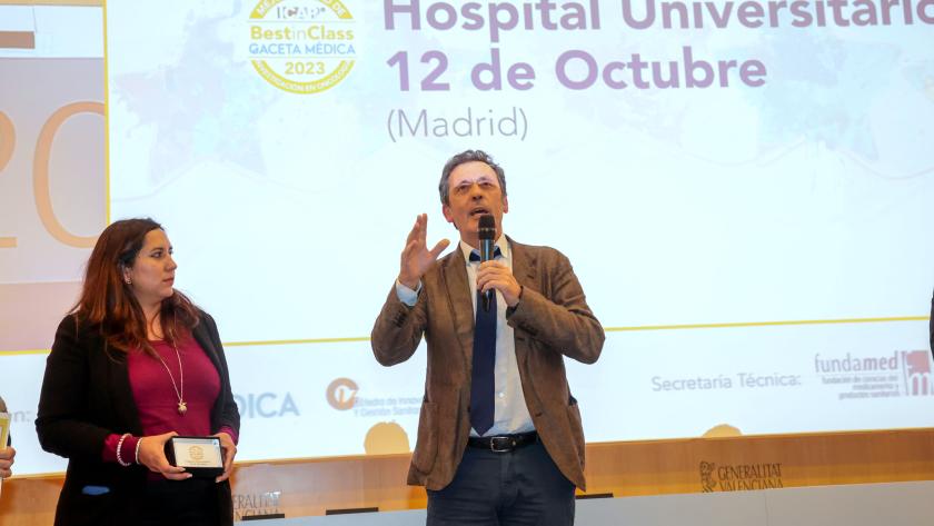 Luis Paz-Ares en sus palabras de agradecimiento tras recoger el premio. Foto cedida por Gaceta Médica. un hombre hablando en un escenario y una mujer al lado
