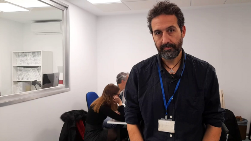 Doctor Alfredo Tagarro Hombre con barba posando delante de mesa con personas trabajando