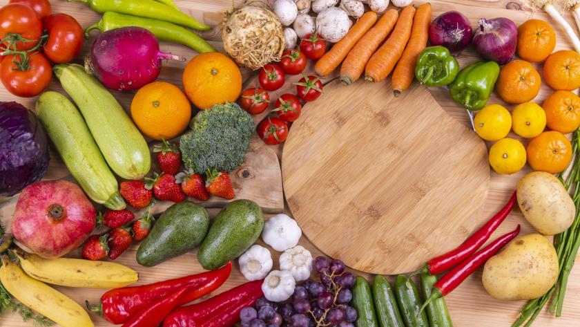 Frutas y verduras en una mesa con una tabla de madera