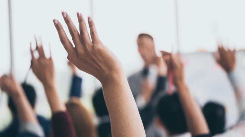 aula Una manos de alumnos alzadas