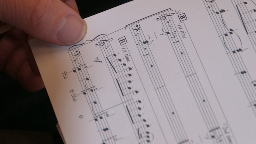 Imagen de una partitura y una mano