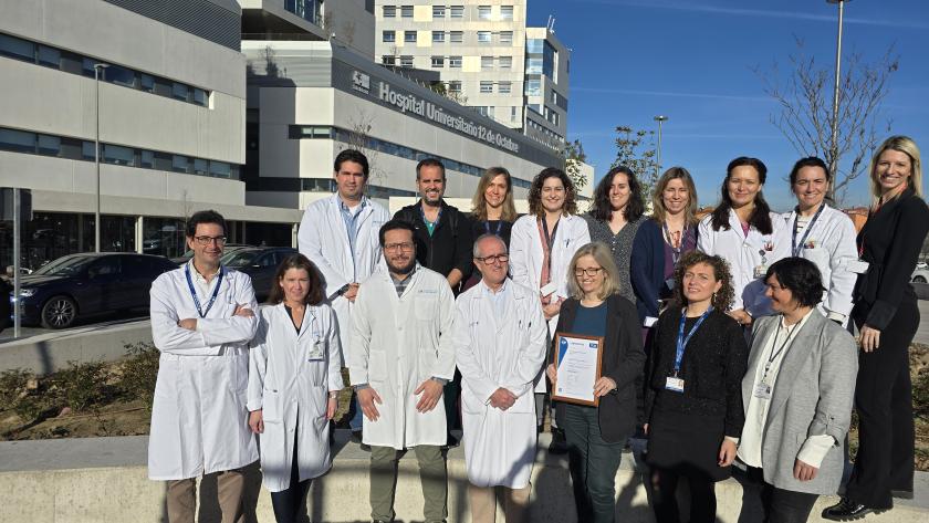 foto de grupo en exterior con batas blancas y Hospital 12 de Octubre detrás