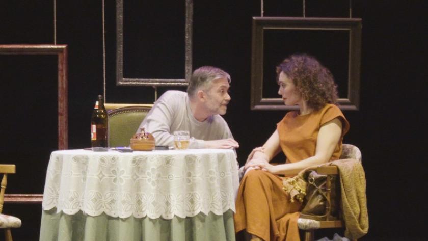 imagen de escena  muestra un hombre y mujer sentados ante una mesa 