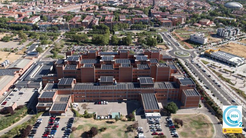 Panorámica aérea del Hospital Universitario Severo Ochoa de Leganés con placas fotovoltaicas y Sello Cálculo 2024