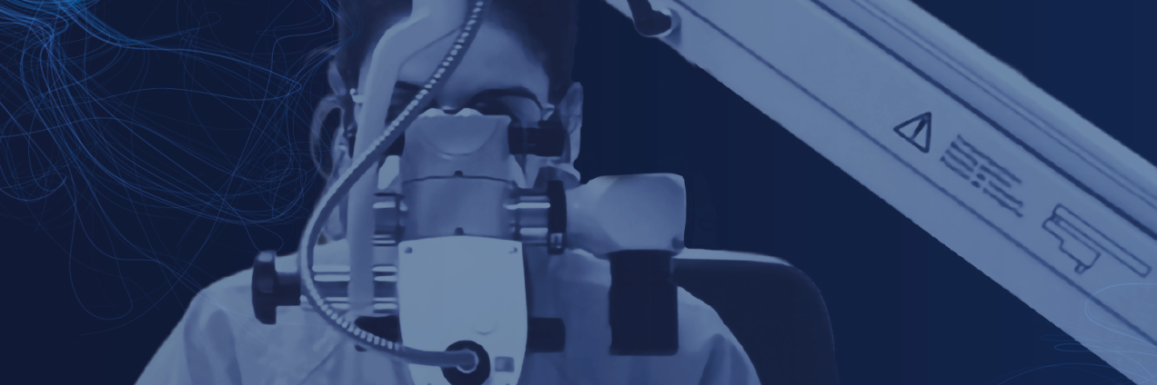 Imagen de una persona con indumentaria de centro hospitalario mirando a través de un microscopio