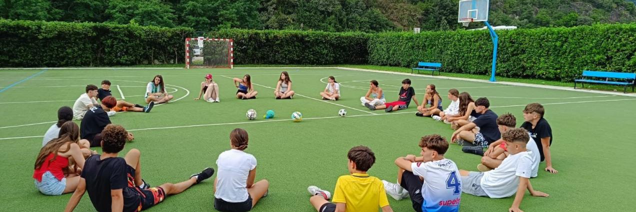 Jóvenes en circulo sentados en césped al aire libre