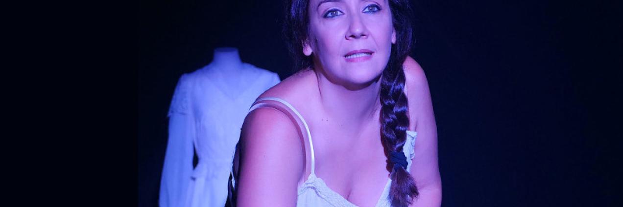 imagen de escena, muestra a la actriz en camisón y detrás de ella sobre un maniquí un vestido blanco de novia