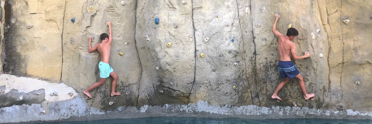 Chicos en una pared de rocódromo