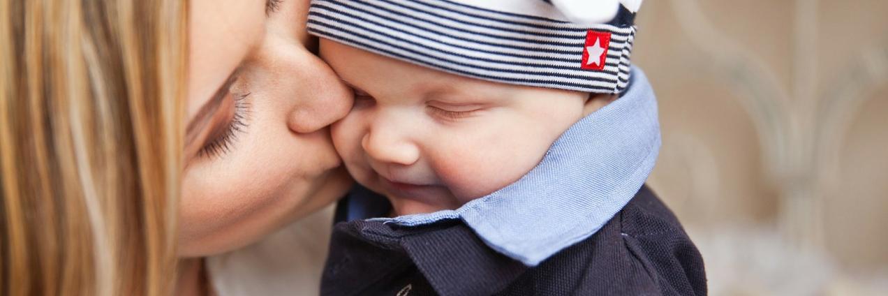 Madre con niño en los brazos dándole un beso