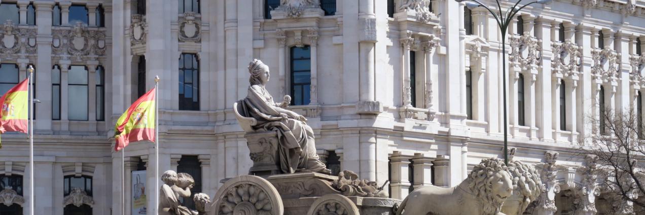 Estatua de la Diosa Cibeles frente al Palacio de Comunicaciones con banderas de España
