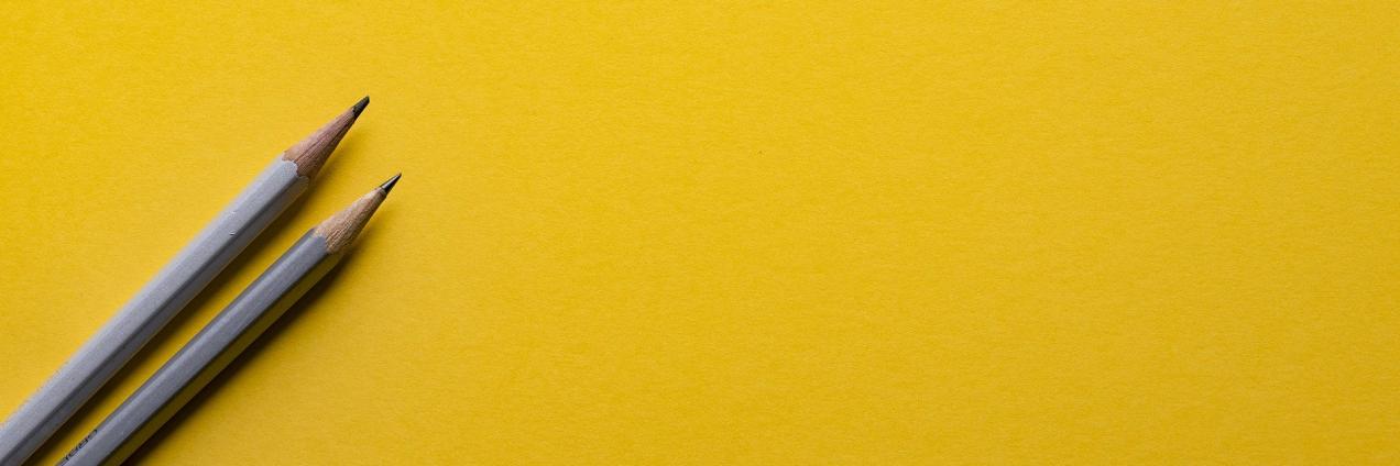 Dos lápices sobre un fondo amarillo