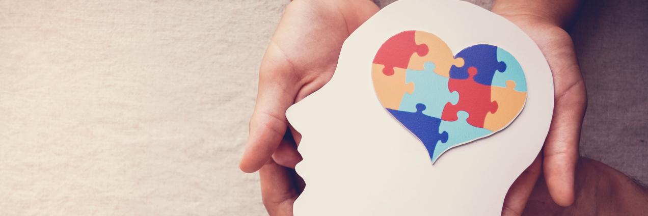 Manos cogiendo cabeza con corazón de puzle