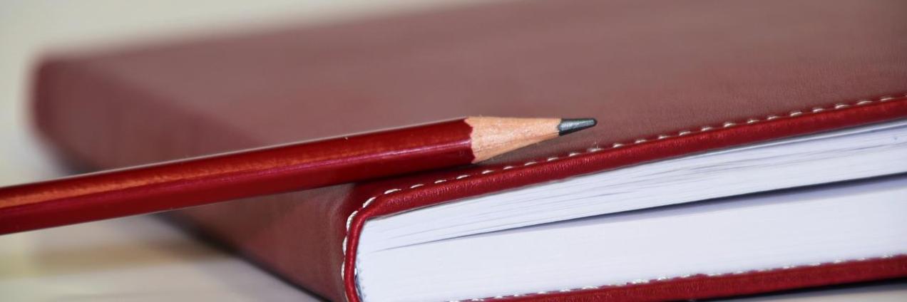 Cuaderno y lápiz rojo