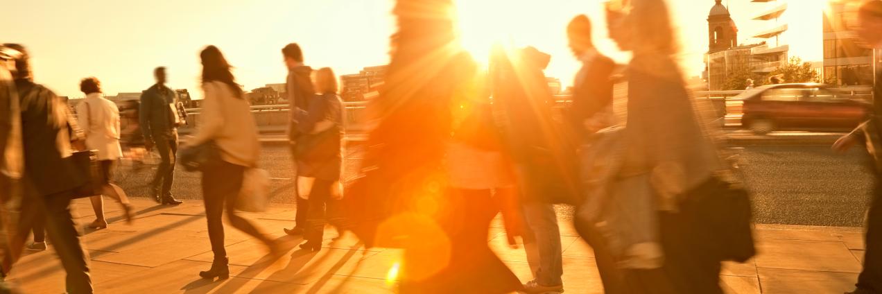 Personas andando con el sol de fondo