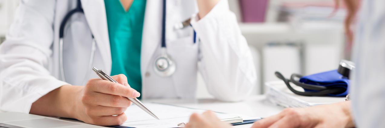 Una doctora atendiendo en consulta a un paciente