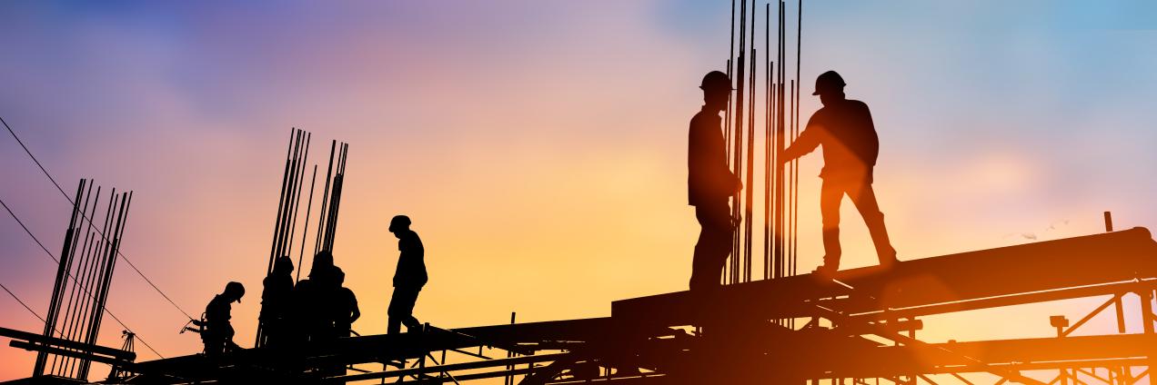 Obreros a contraluz sobre forjado de obra trabajando ferralla 