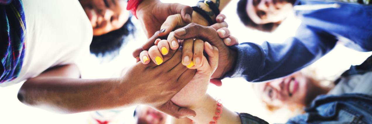 Grupo de jóvenes juntando las manos en el centro