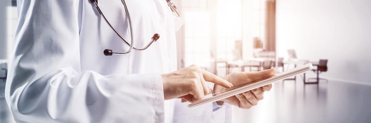 médico con fonendo escribiendo en tablet