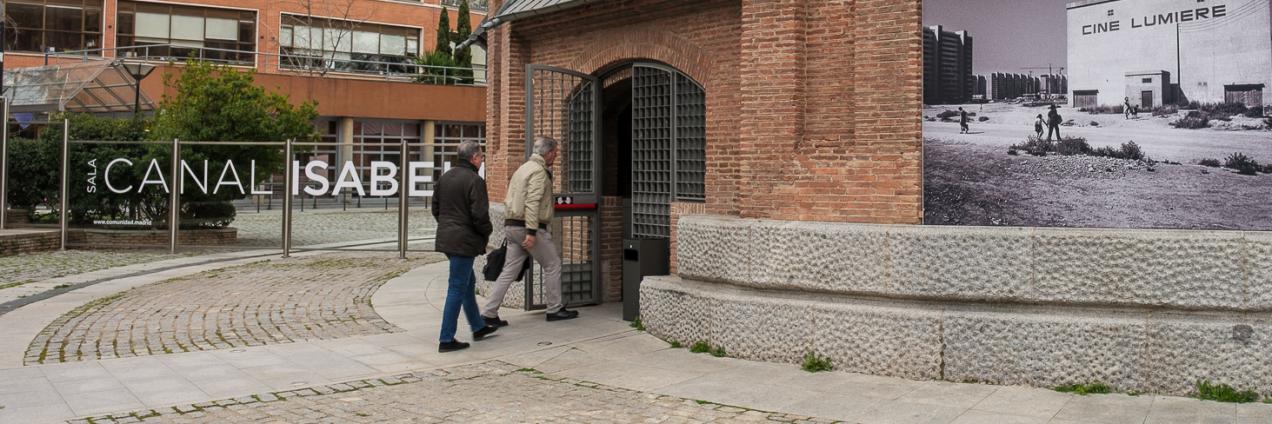 Persona entrando por una puerta de un edificio de ladrillo