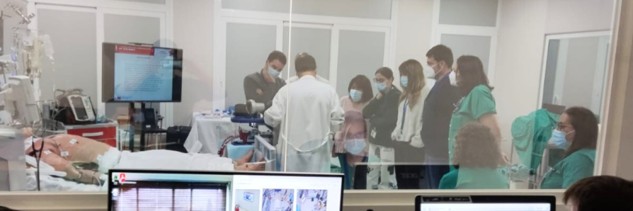 profesionlaes sanitarios simulando una intervención y vistos a través de un cristal