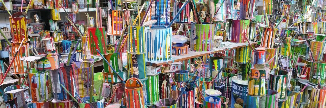 Muchos botes y pinceles de colores usados