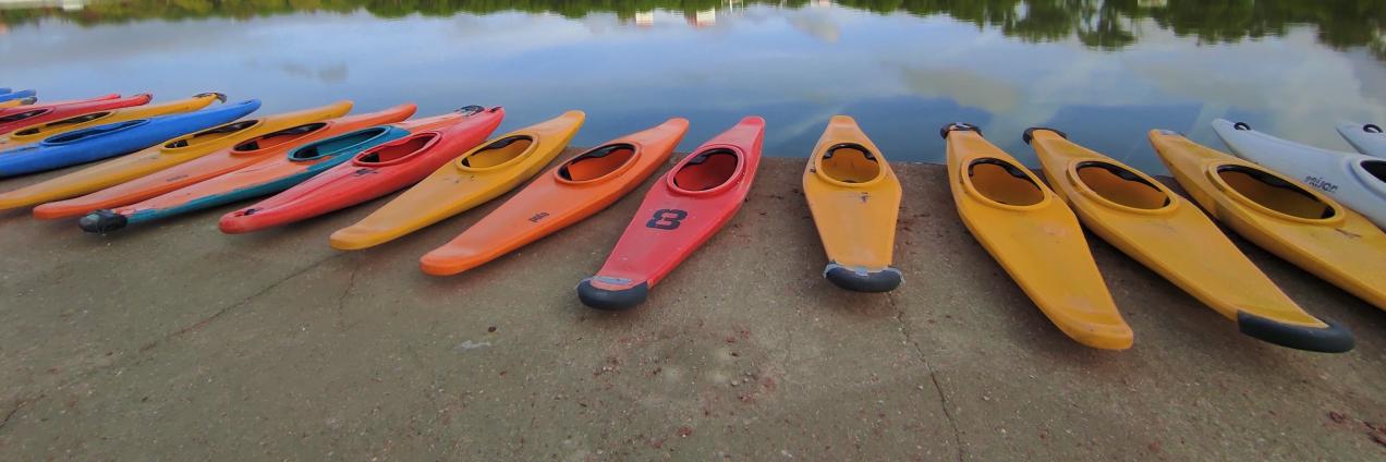 Piraguas de varios colores al borde de un lago