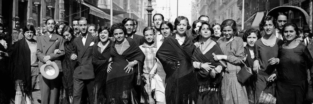 Grupo de personas en la calle mirando y sonriendo a la cámara
