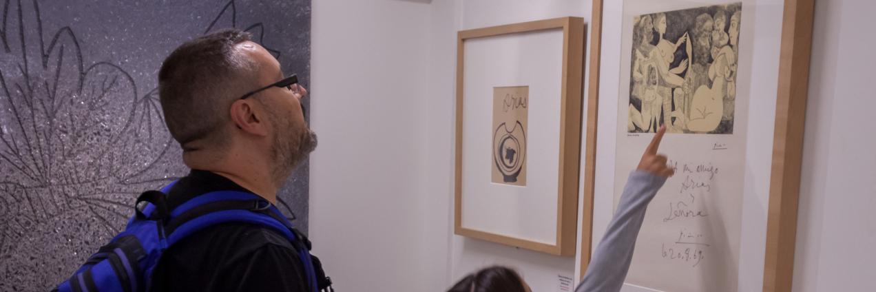 Un hombre y una niña visitando una exposición