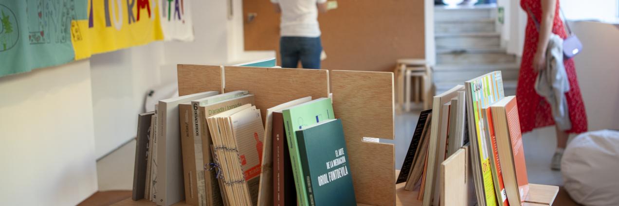 Sala de exposiciones con una estancia llena de libros y paneles con recursos educativos